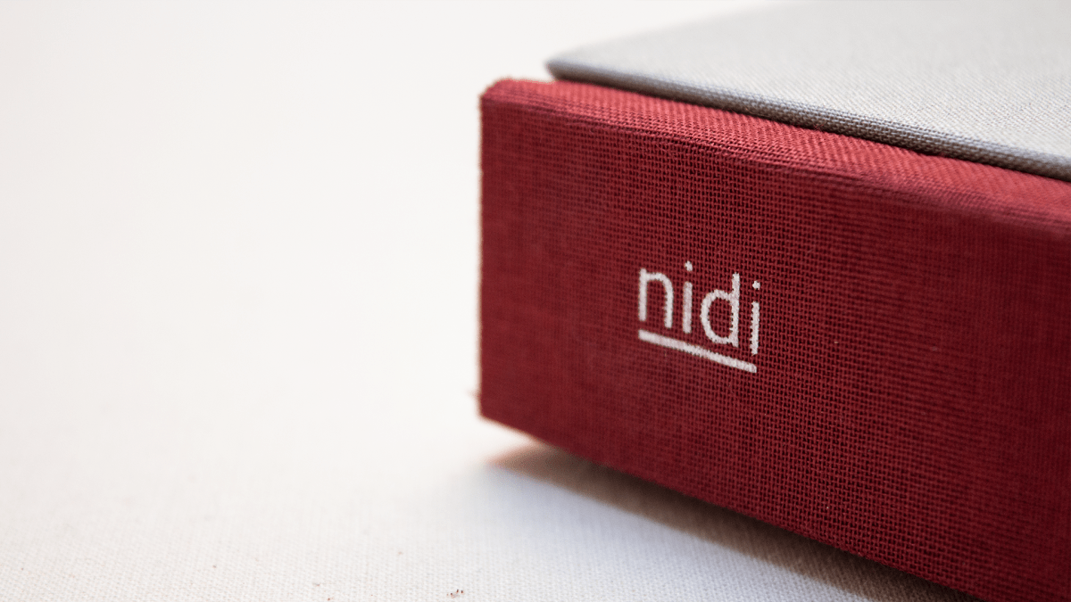 Dorso del catalogo Elements Nidi con rilegatura tessile e marchio serigrafato progettato da Grucciadesign