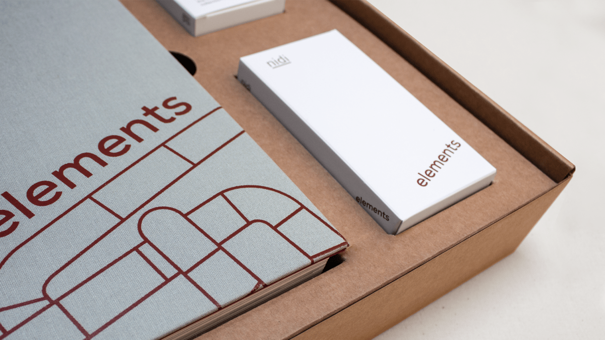 Packaging catalogo Elements Nidi progettato da Grucciadesign con catalogo e carte finiture personalizzate all’interno della scatola coordinata